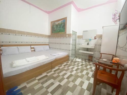 a bedroom with a bed and a table and a chair at Khách sạn Sơn Hà in Can Tho