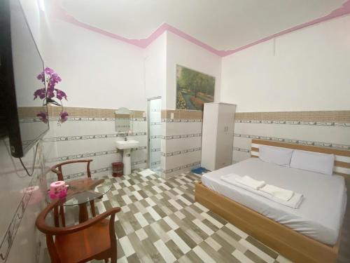 a bedroom with a bed and a table and a sink at Khách sạn Sơn Hà in Can Tho