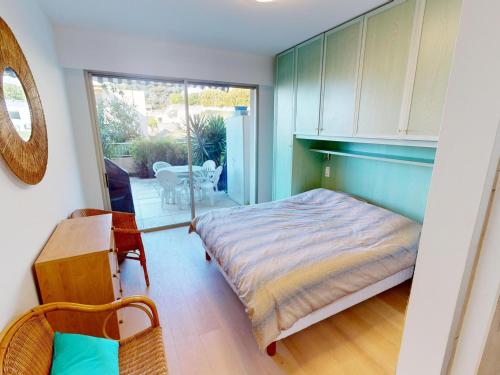 une chambre avec un lit et une porte coulissante en verre dans l'établissement 3P climatisé avec grande terrasse, piscine et WiFi - FR-1-196-350, à Menton