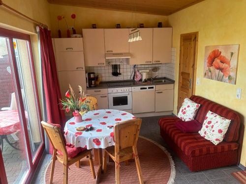 ein Wohnzimmer mit einem Tisch und einem roten Sofa in der Unterkunft Ferienapartments Seeblick Dahmen in Dahmen