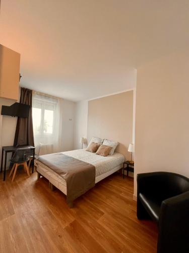 um quarto com uma cama, uma secretária e uma cadeira em Studio 2 pers face gare SNCF Appart Hotel le Cygne D2 em Bourges