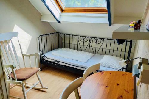 um pequeno quarto com uma cama, uma mesa e uma janela em Kustverhuur, Park Schoneveld, Duinroos 102 em Breskens