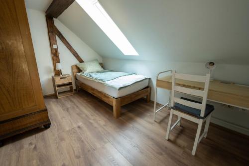 1 dormitorio pequeño con 1 cama y 1 silla en Ferienhaus Zum Waldrand, en Erfweiler