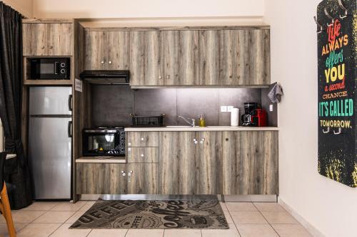 a kitchen with wooden cabinets and a refrigerator at Dantis Place in Nafplio wheel chair accessible in Nafplio