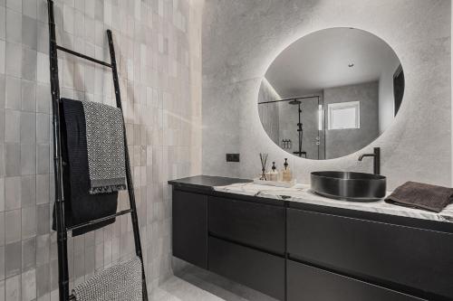 a bathroom with a sink and a mirror at Luxurious large home Perfect for your group in Hafnarfjörður