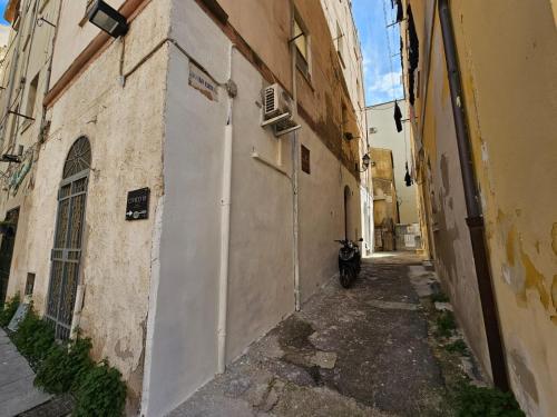 an alley with a motorcycle parked next to a building at Civico 10 in Sassari