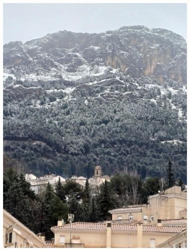 a mountain covered in snow with houses and trees at Cazorla LIVE in Cazorla