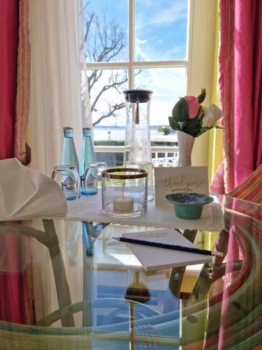 a glass table with vases and a window at Boutique Hotel Villa am See in Hagnau