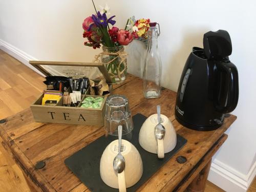 a table with a tea kettle and spoons on it at Number Six in Truro