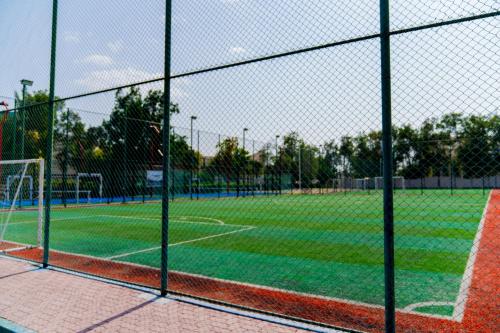 a baseball field with a fence and a soccer field at eStay Hotel in Dubai