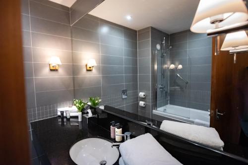 a bathroom with a sink and a toilet and a mirror at Lakeside Park Hotel & Spa in Ryde