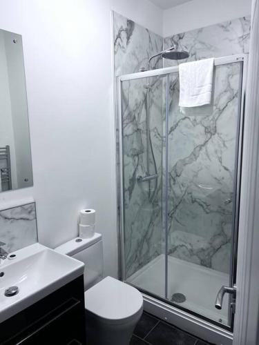 a bathroom with a shower and a toilet and a sink at FREE PARKING - Stunning 2-BR near Salford Royal in Manchester