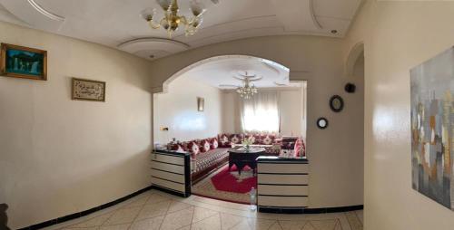 un soggiorno con un divano e un tavolo di Appartement meublé à louer a Meknès