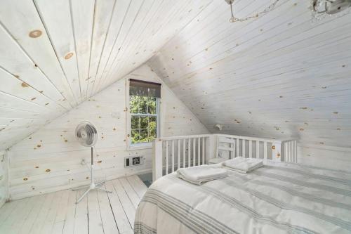 um quarto branco com uma cama num sótão em Welcome to Golden Field Farmhouse em Wellington