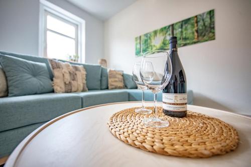 butelkę wina i kieliszek na stole w obiekcie Voll ausgestattetes, neues Rennsteig Apartment Ruhla w mieście Ruhla