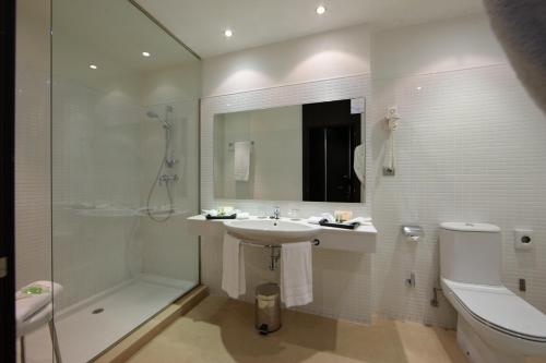 y baño con lavabo, ducha y aseo. en Aparthotel Attica 21 Vallés, en Sabadell