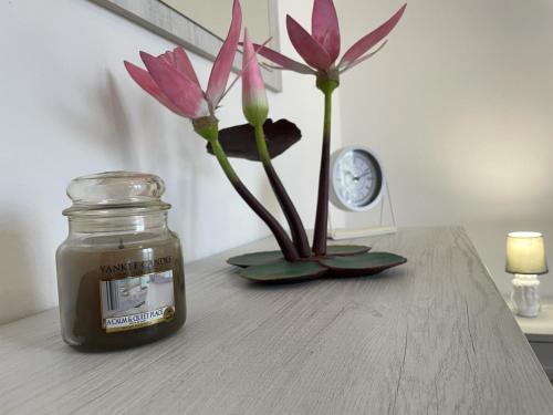 a jar of honey and a vase with flowers on a table at Water Lily Apartment in Bardello