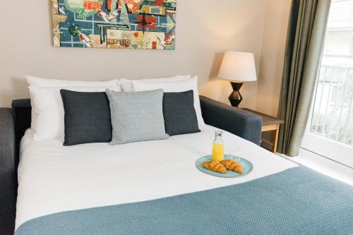 una cama con un plato de comida encima en Marlin Apartments Commercial Road - Limehouse en Londres