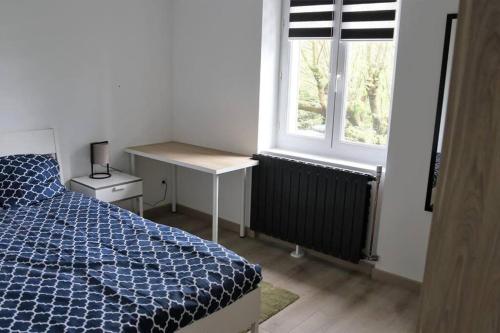 a bedroom with a bed and a desk and a window at Maison de 100 M2 équipée de 4 chambres. in Valence