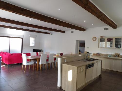 Il comprend une cuisine et une salle à manger avec un canapé rouge. dans l'établissement Spacieuse villa a St Cyprien pour 15, à Saint-Cyprien