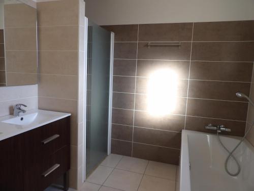 a bathroom with a sink and a shower with a light at Spacieuse villa a St Cyprien pour 15 in Saint-Cyprien