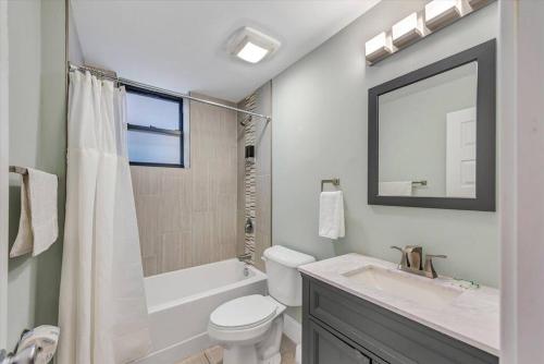 a bathroom with a toilet and a sink and a mirror at Side by Side Townhomes in Tower Grove 916&918 in Tower Grove