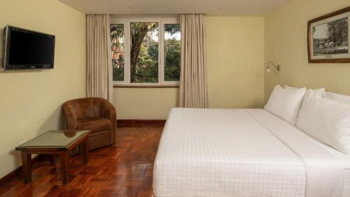 a hotel room with a bed and a chair at Fairview Hotel Nairobi in Nairobi