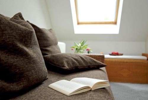 an open book sitting on a couch with a pillow at Trassenheide, Ferienhaus Teuber I in Trassenheide