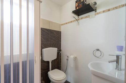 La salle de bains est pourvue de toilettes et d'un lavabo. dans l'établissement Villa Luana Punta Prosciutto, à Punta Prosciutto