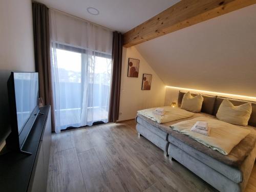 ein Schlafzimmer mit einem Bett und einem großen Fenster in der Unterkunft Hotel Alte Linde in Feldafing