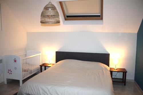 a bedroom with a white bed with two nightstands and two lamps at Villa Elsa in Durbuy