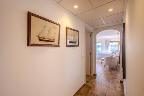 a hallway with two pictures of a sail boat on the wall at La Posada del Mar in Denia