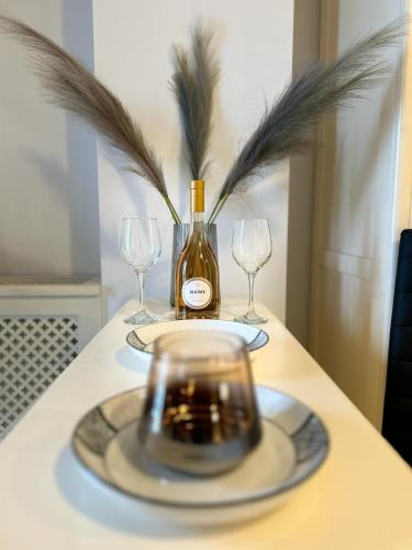 a bottle of wine sitting on a table with glasses at Airport Residence in Otopeni