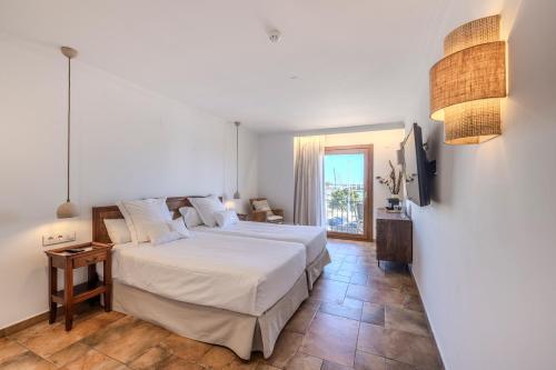 a bedroom with a large bed and a television at La Posada del Mar in Denia