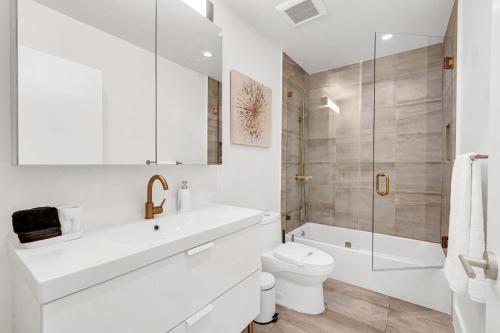 a white bathroom with a toilet and a shower at Samadhi - NEW 15 min drive to Ultra, by Newman Hospitality in Miami Shores