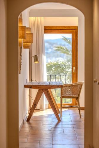a dining room with a wooden table and a window at La Posada del Mar in Denia