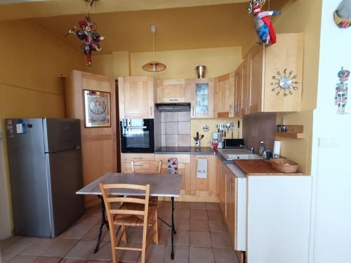 Il comprend une cuisine équipée d'un réfrigérateur, d'une table et de chaises. dans l'établissement Appartement quartier Libération, à Nice