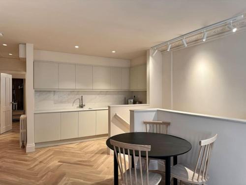 a kitchen with a table and chairs and a counter at Luxury Shoreditch One Bedroom Apartment in London