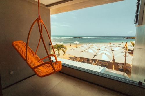 a swing in a room with a view of the beach at Marilyn Pousada Morro in Morro de São Paulo