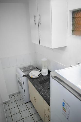 a white kitchen with a stove and a dishwasher at Hotel Pousada Estacao Do Sol Natal in Natal