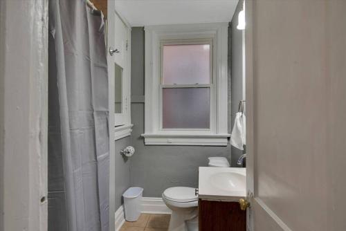 baño con aseo y lavabo y ventana en Two Charming Units 1W&2W, en Tower Grove