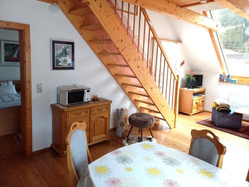 a living room with a table and a staircase at Apartmenthaus Kometerhof in Flattach