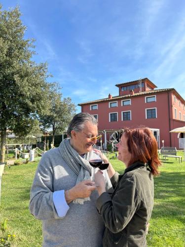 Um homem e uma mulher a beber um copo de vinho. em Resort Il Casale Bolgherese - by Bolgheri Holiday em Bolgheri