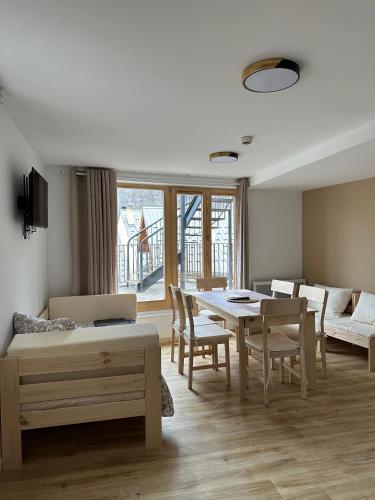 un salon avec une table, des chaises et un canapé dans l'établissement Résidence le Prorel - Serre chevalier, à Saint-Chaffrey