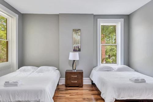 Duas camas num quarto branco com duas janelas em Central St Louis apartment 1E em Soulard