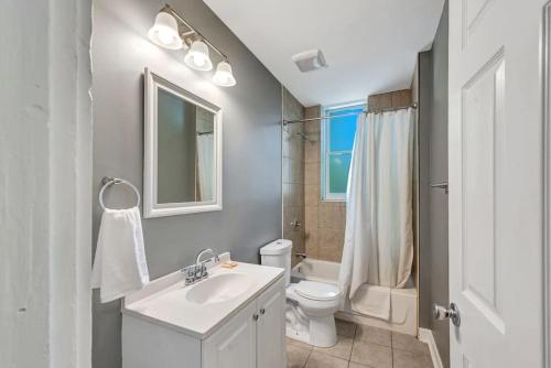 La salle de bains est pourvue d'un lavabo blanc et de toilettes. dans l'établissement Central St Louis apartment 1E, à Soulard