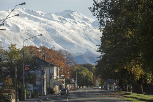 a street with a snow covered mountain in the background at Pinewood Motels in Fairlie