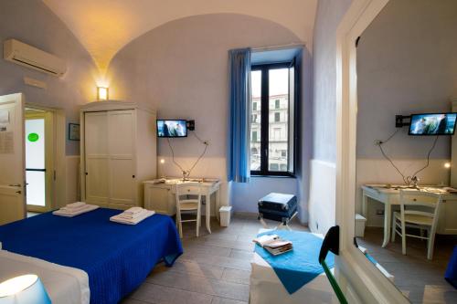 a room with two beds and two tables and a window at Il Giardino di Tonia - Oplontis Guest House - Bed & Garden - in Torre Annunziata