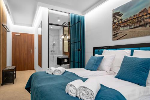 two beds in a bedroom with blue and white at Pensjonat eSENtia in Zgorzelec