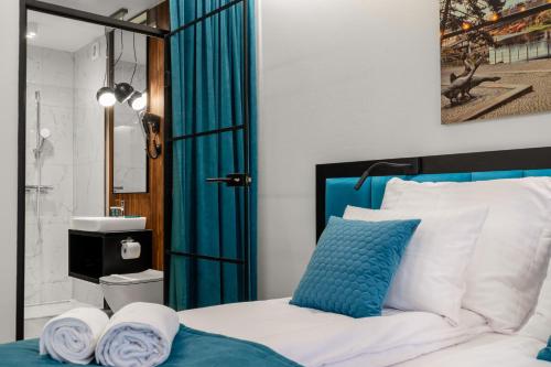 a bedroom with a bed with blue and white pillows at Pensjonat eSENtia in Zgorzelec